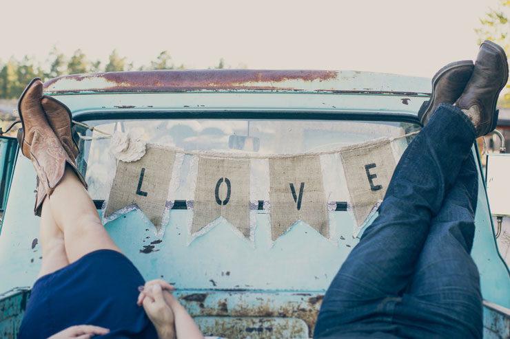 Burlap wedding Love sign with couple in the back of an old pick-up truck.