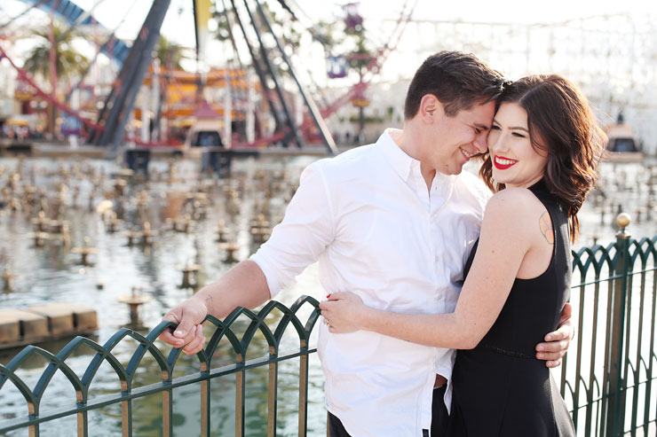 Couple in front of ferris wheel at Disneyland Theme Park in CA. Engagement photos by Scot Woodman Photography