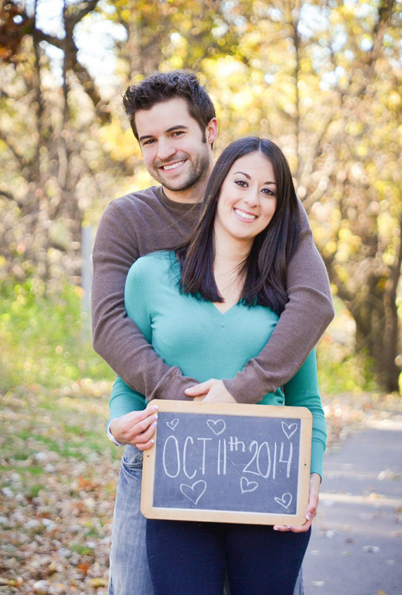 couple holding save the date chalkboard wedding sign