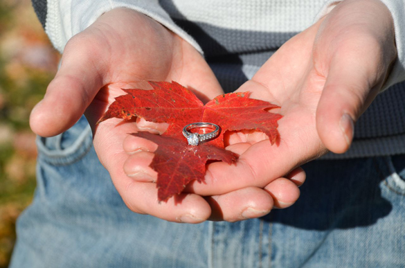 Fall engagement ring shot on red maple leaf