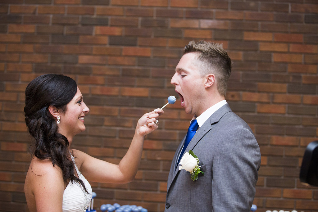 bride feeding groom a blue cake pop