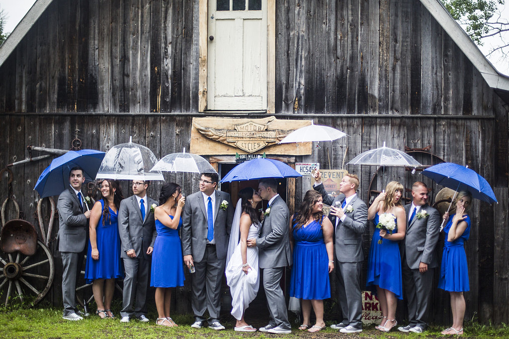 blue umbrellas and wedding party in the rain
