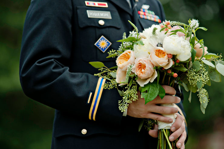 Military groom holding wedding bouquet