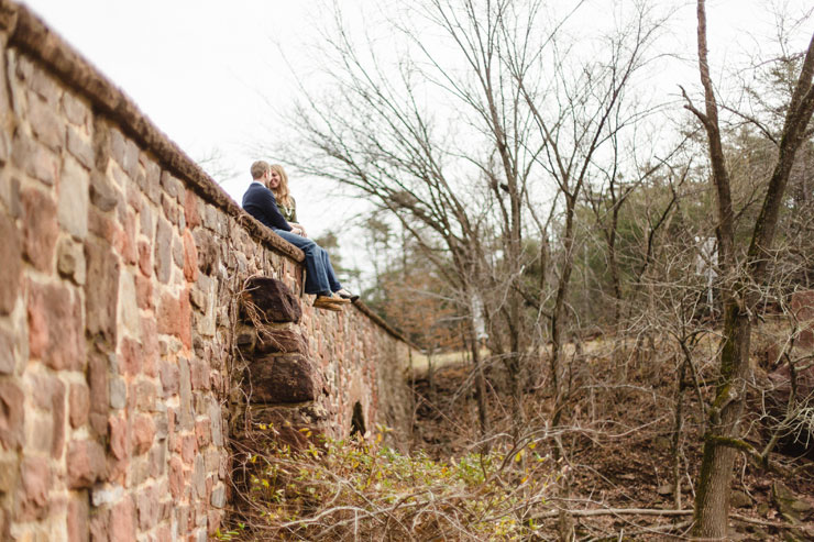 Manassas Battlefield National Park engagement photos of couple sitting on an old stone wall (photos by Hay Alexandra Photography).