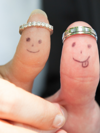 newlyweds displaying thumbs with wedding rings and smiley faces