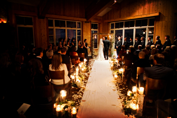 Walking down a candlelit aisle in winter destination wedding in Park City, Utah