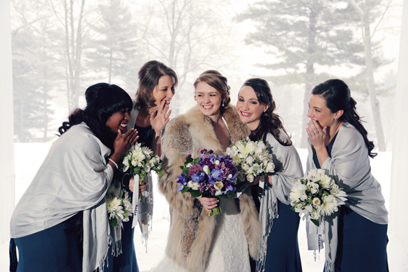 bride wearing a fur coat and bridesmaids wearing pashminas in winter wedding 
