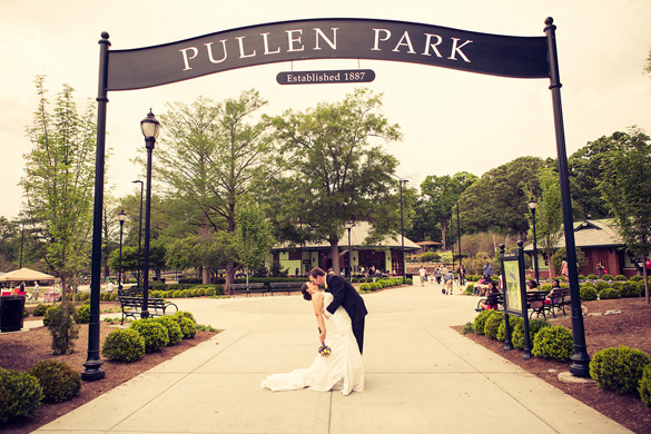 bride and groom under Pullen Park sign