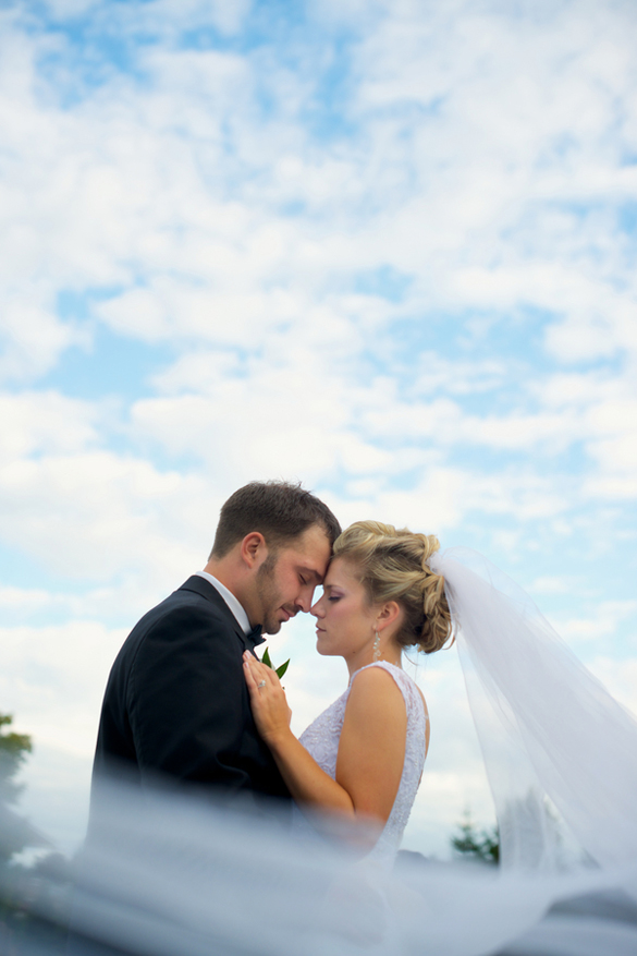 outdoor wedding photo with veil in foreground and sky above