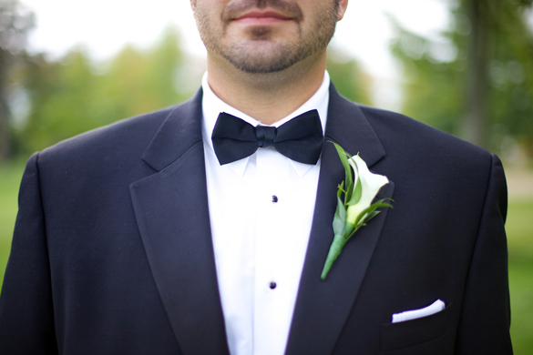 groom in black bow tie and calla lily boutonniere