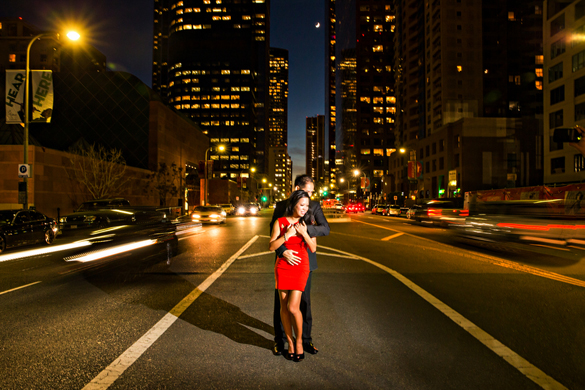 nightime engagement photo of couple with L. A. city skyline in background