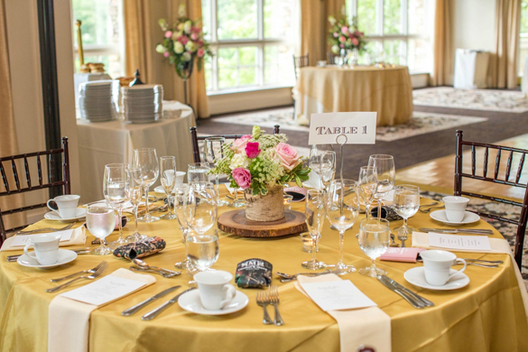 wood rounds and gold tablecloth on wedding reception table