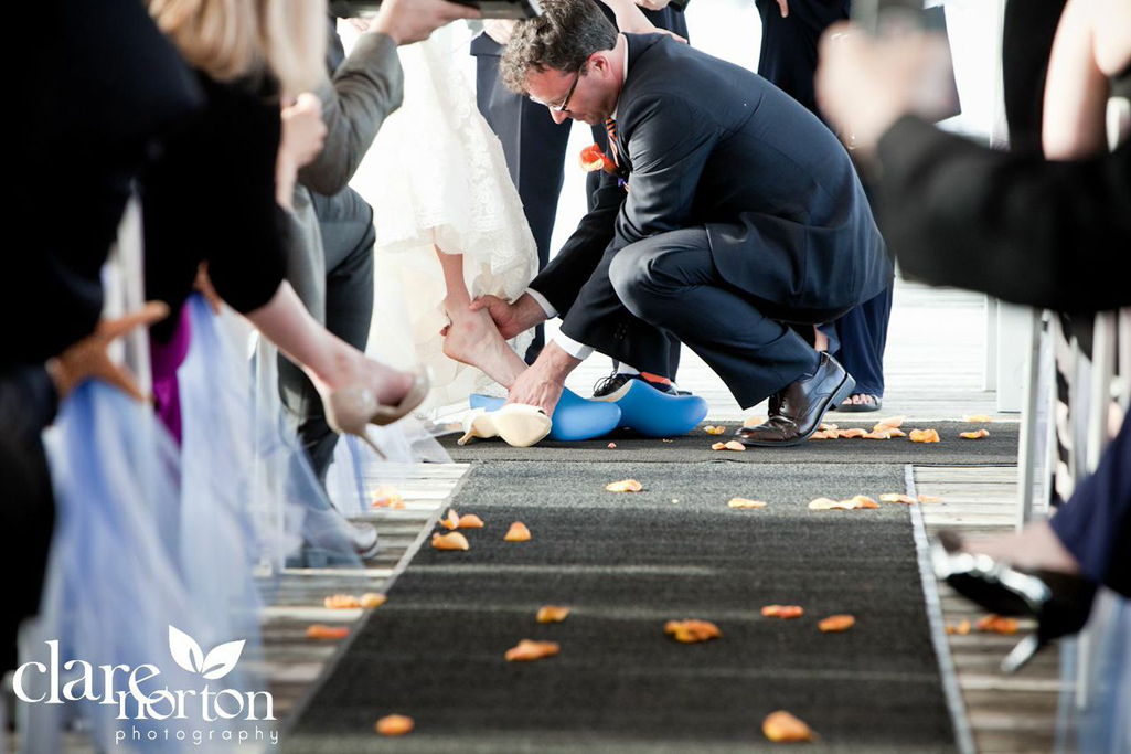 Groom putting on Dutch wedding shoes in clog ceremony