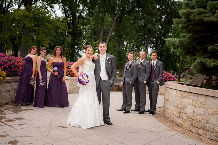 bridesmaids in purple dresses and groomsmen in gray