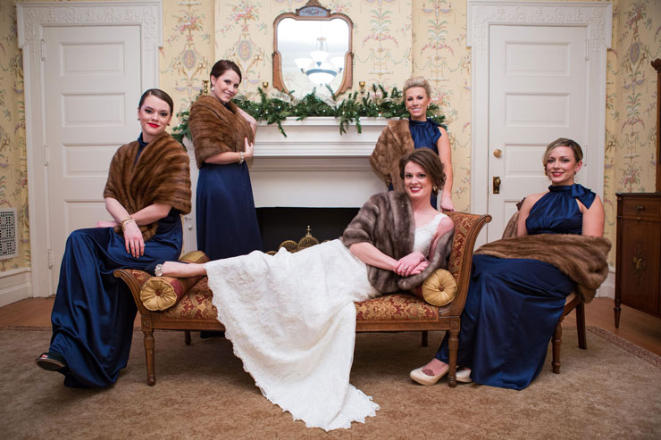 Winter themed wedding with bridesmaids in blue floor length dresses and fur stoles